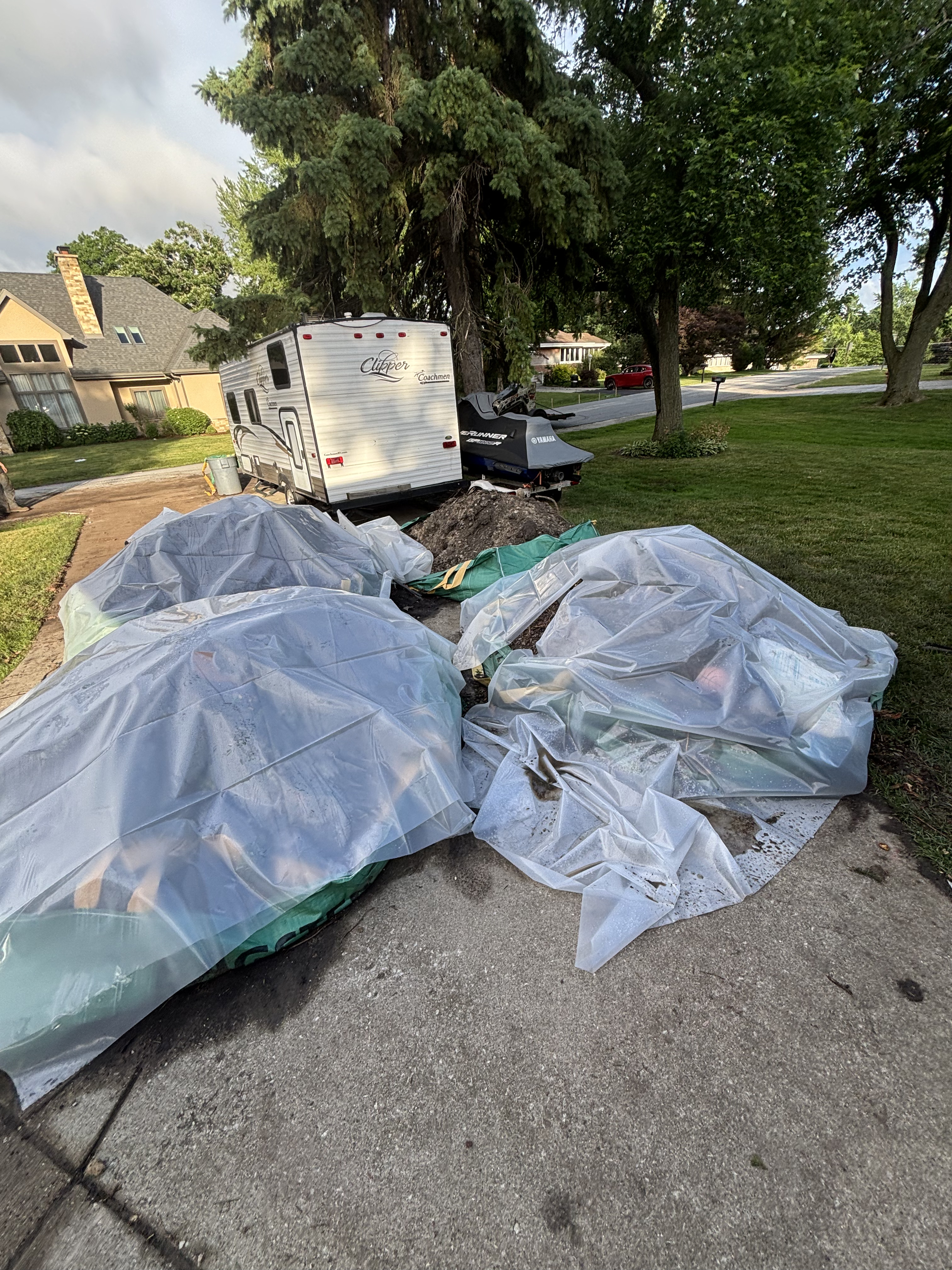Large debris bags lined up at curb after yard cleanup