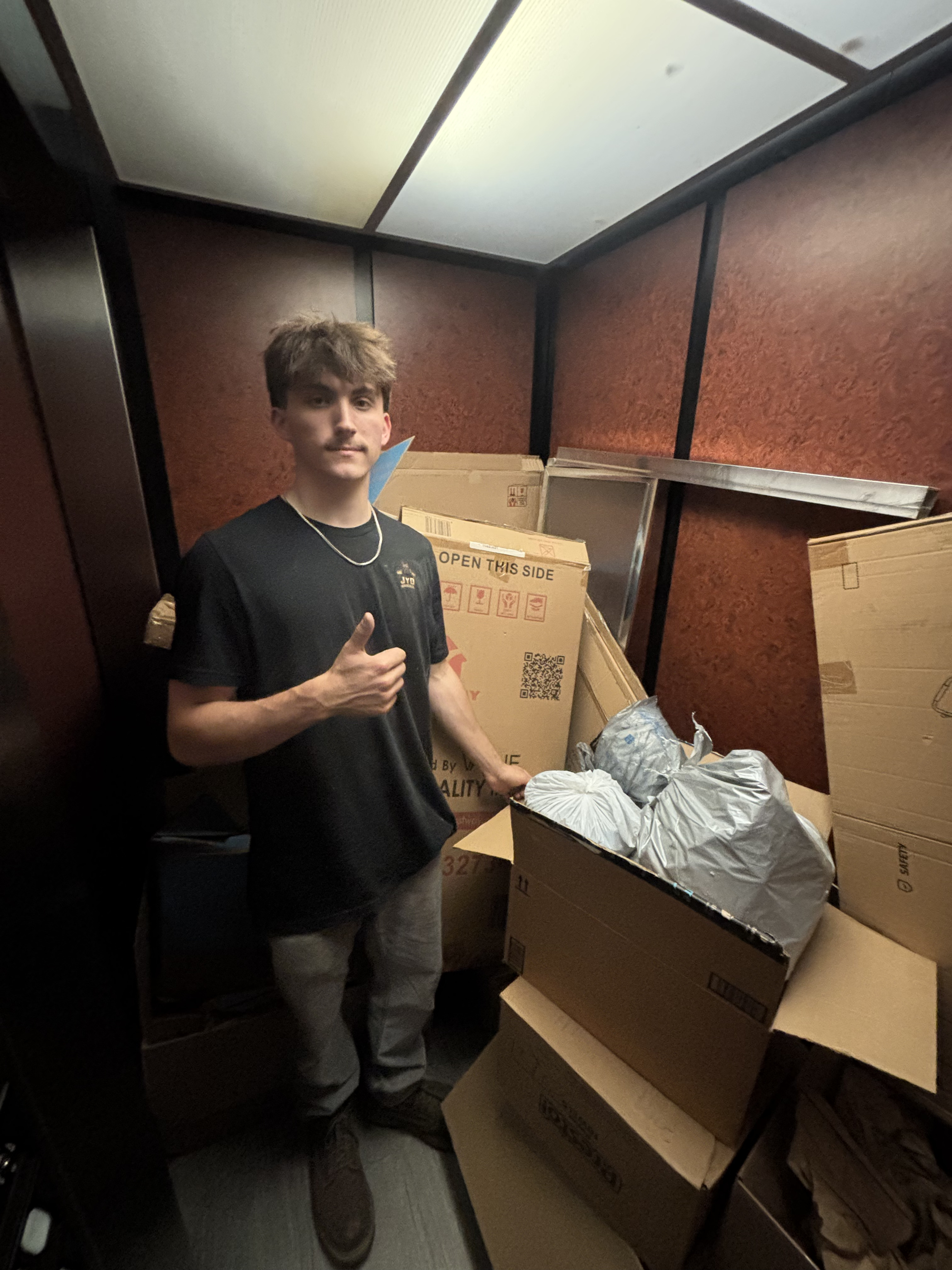 Worker in elevator hauling boxes during estate cleanout