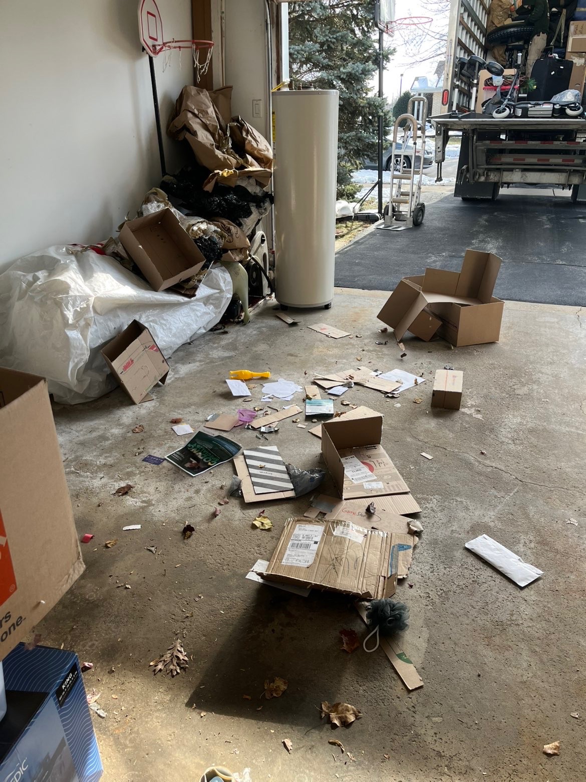 Garage floor covered in debris and cardboard