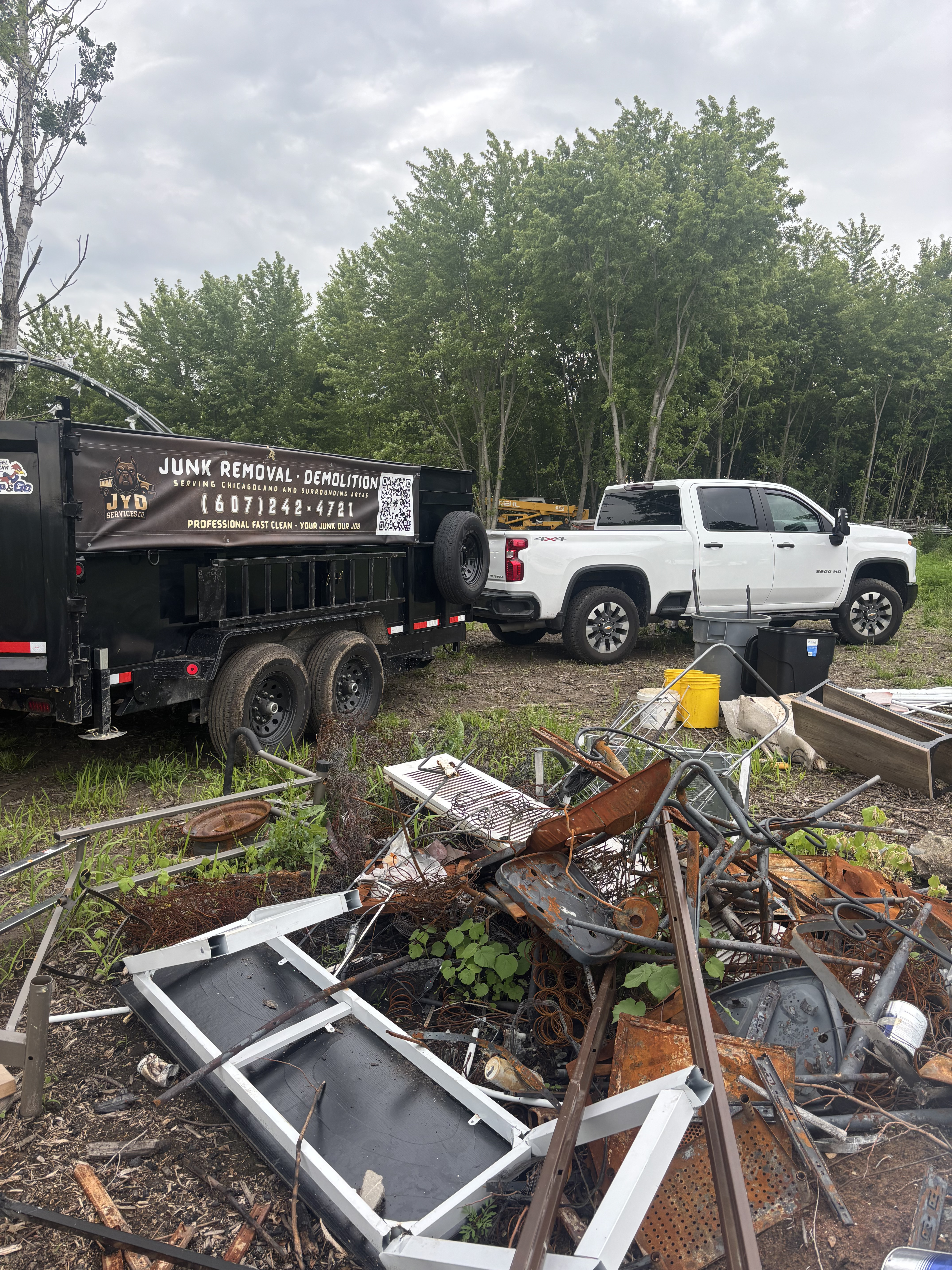 JYD branded trailer and truck at scrap metal job site