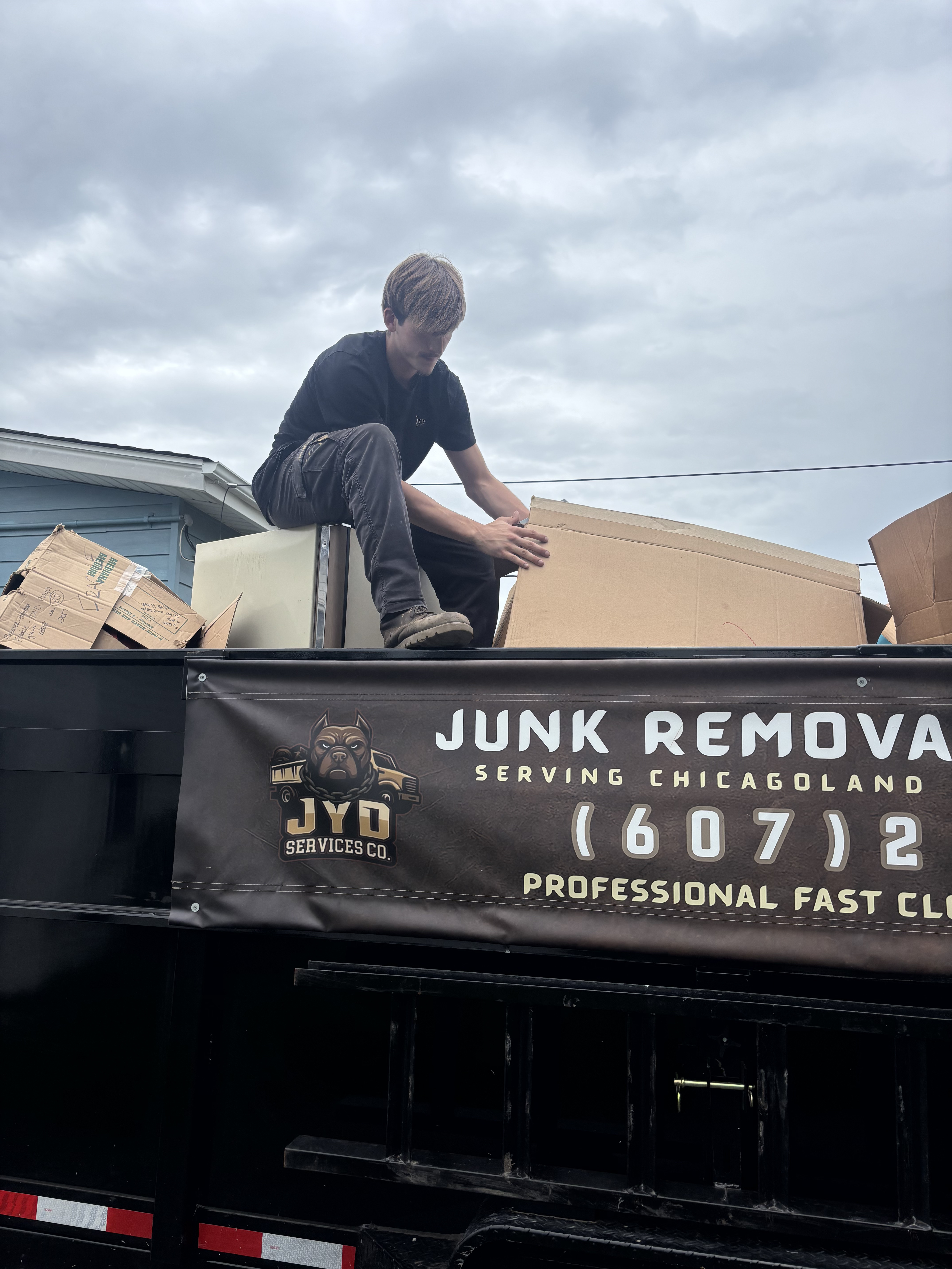Worker loading boxes onto the JYD Services trailer