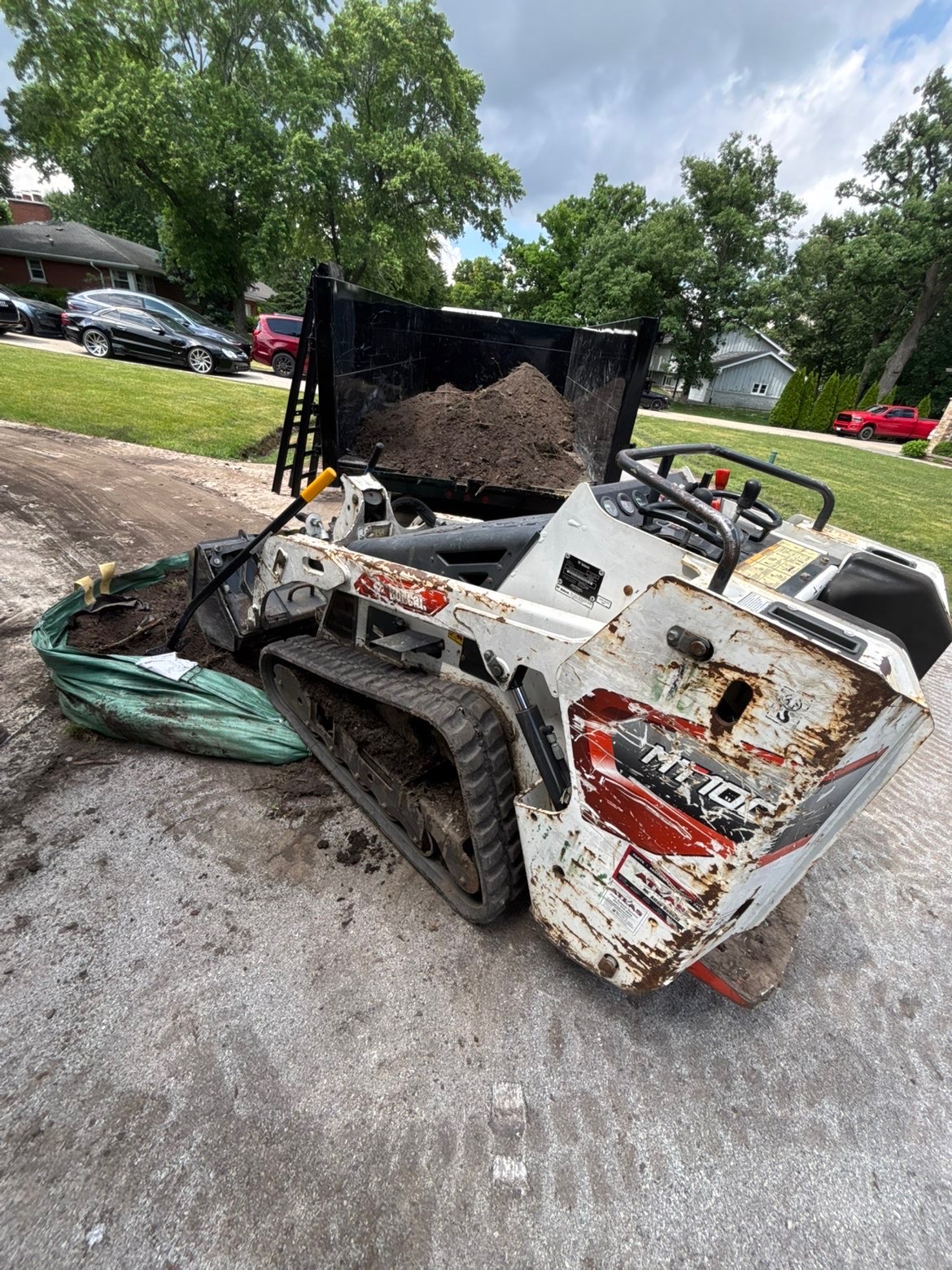 Bobcat mini skid steer hauling dirt — heavy equipment for tough jobs