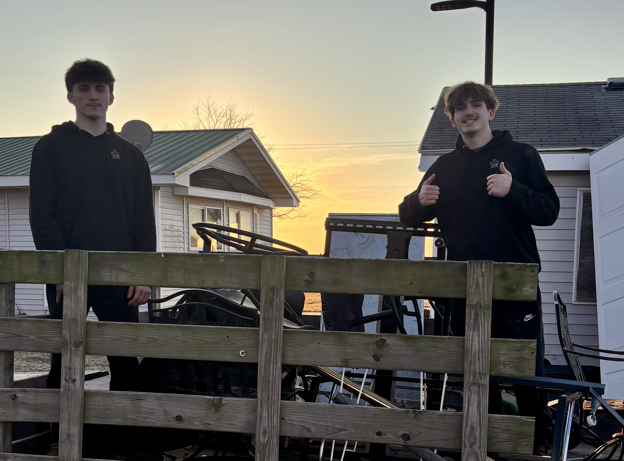 Brothers on flatbed truck at sunset