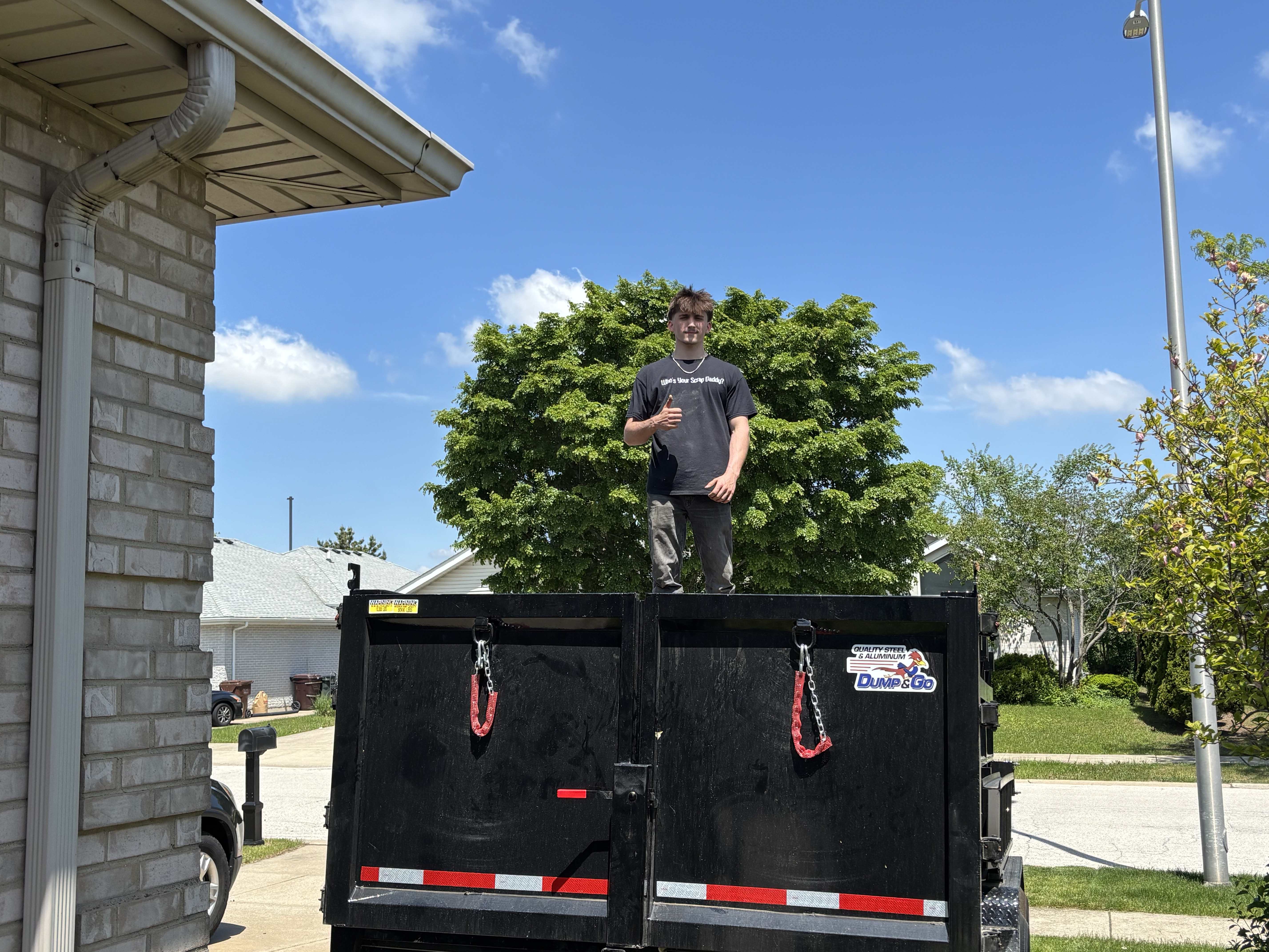 Worker on top of empty JYD trailer on a sunny day
